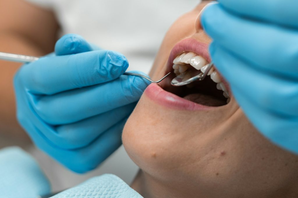 The dentist works in a cozy dental office, providing effective dental care, and the patient in the